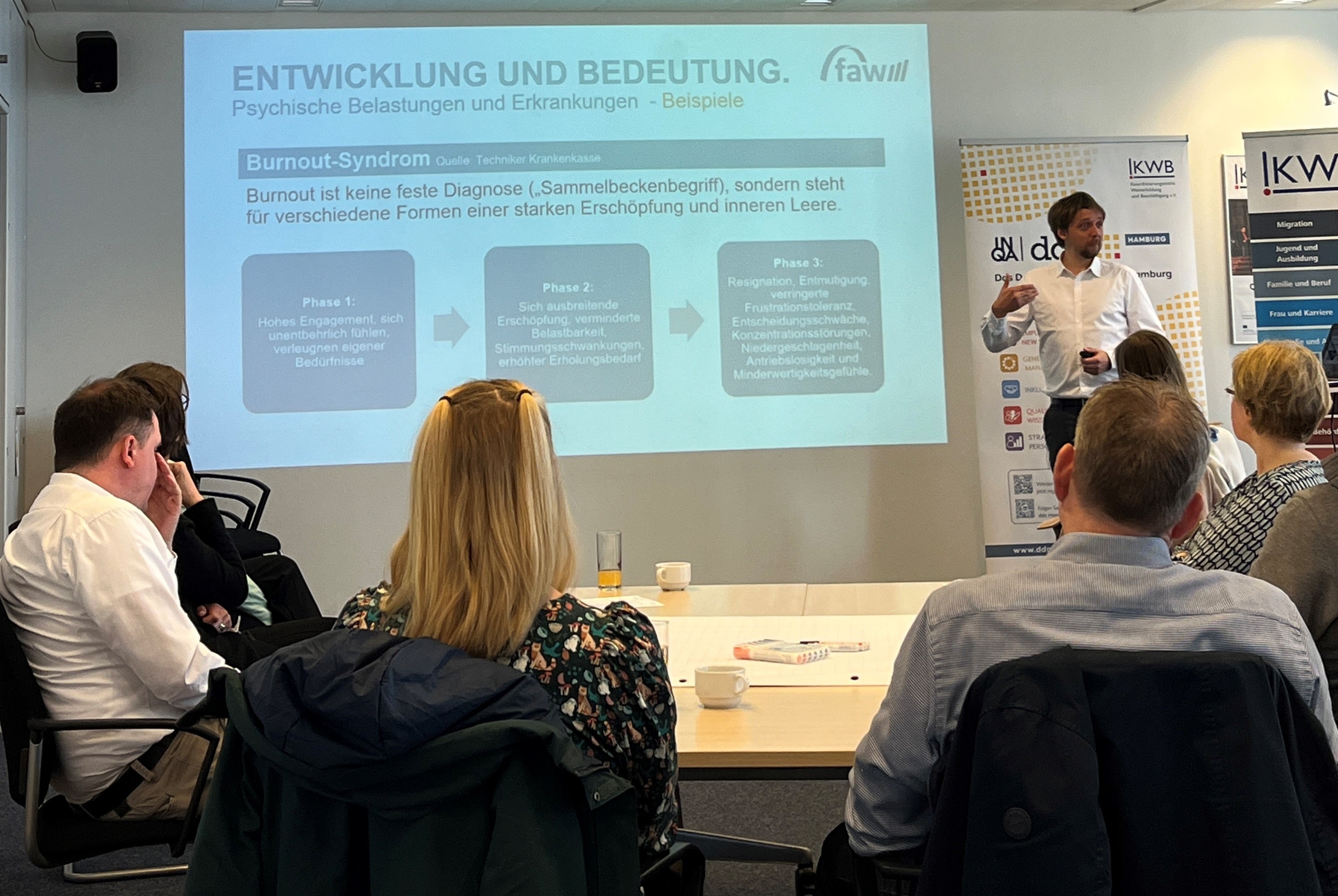 Mika Fischer steht vor seiner Präsentation und spricht zum Publikum.